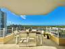 Covered balcony featuring stone flooring and white metal railing