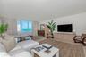 Living space featuring large windows, neutral wall tones, light-toned wood-finish flooring, and built-in cabinetry