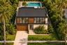 Two-story contemporary residence featuring stone-veneer exterior cladding, wood-finish paneling, an integrated garage, a private swimming pool, and st