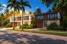 Modern multi-unit residential structure featuring stone veneer siding, wood-toned panels, recessed exterior lighting, private upper-level balconies wi