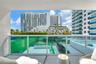 Covered balcony featuring a glass panel railing and solid surface flooring