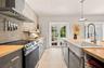 Kitchen featuring butcher block countertops, a farmhouse-style apron sink, a herringbone-patterned tile backsplash, stainless steel appliances, and Fr
