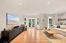 Living area featuring wood-finish flooring, recessed lighting, double French doors, and built-in shelving