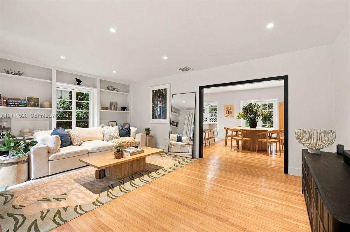 Living area featuring wood-finish flooring, recessed lighting, and expansive floor-to-ceiling built-in shelving