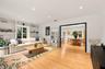 Living area featuring wood-finish flooring, recessed lighting, and expansive floor-to-ceiling built-in shelving