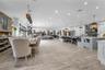 Open-concept layout featuring wood-finish flooring, a kitchen island with built-in booth seating, recessed lighting, and custom cabinetry