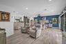 Wood-finish flooring, sliding barn door, recessed lighting, ceiling fan with integrated lighting, and multiple windows