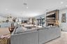 Open-concept living area featuring stacked stone fireplace, distressed timber mantel, wood-finish flooring, recessed lighting, and multi-panel sliding