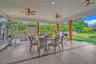 Covered patio featuring wood-finish flooring, recessed lighting, ceiling fans with integrated light fixtures, and structural support posts