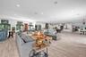 Open-concept interior featuring light wood-finish flooring, recessed lighting, and white cabinetry