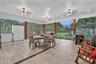Screened patio featuring wood-finish tile flooring, recessed lighting, and triple ceiling fans with integrated light fixtures