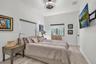 Wood-finish flooring, high ceilings, recessed ceiling fan with integrated lighting, and window with roller shade
