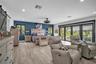 Wood-finish flooring, accent wall, sliding barn door, recessed lighting, and multi-panel glass door system