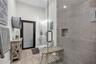 Walk-in shower featuring glass paneling, floor-to-ceiling tile surround, and a recessed soap niche, paired with wood-finish flooring and a frosted-gla