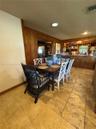 Dining area featuring stone tile flooring, natural wood-paneled walls, and built-in kitchen cabinetry with a serving counter