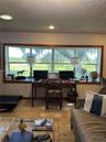 Large picture window featuring wood trim, recessed ceiling lighting, and stone-tile flooring