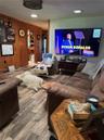 Living area featuring wood-finish flooring, wood paneling, and recessed ceiling lighting