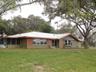 Single-story exterior featuring metal roofing, a screened porch, decorative window shutters, and a bow window