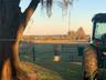 Expansive acreage featuring mature oak trees, open pastureland, and metal perimeter fencing