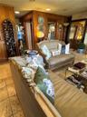 Living space featuring vertical wood-paneled walls, neutral-toned stone tile flooring, and recessed ceiling lighting