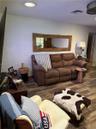 Wood-finish flooring throughout, recessed ceiling lighting, and a custom live-edge wood-framed wall mirror