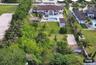 Expansive estate grounds featuring a multi-structure layout, a paved pool deck, a private swimming pool, and mature perimeter landscaping