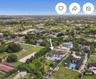 Aerial perspective of a multi-story residence featuring a tile roof, an expansive swimming pool, a covered patio, and large private acreage