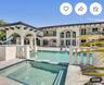 Two-story estate exterior featuring a tiled swimming pool with an integrated spa, stone balustrade railings, a covered patio with decorative support b