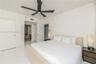 Interior room featuring polished white tile flooring, matte black ceiling fan with integrated lighting, and white smooth-finish interior doors