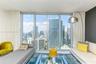Floor-to-ceiling windows featuring expansive urban panoramas, sleek white tile flooring, and a neutral wall color palette