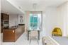 Kitchen featuring dark wood-finish cabinetry, black stone countertops, and built-in stainless steel appliances, paired with high-gloss tile flooring a