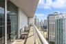 Covered balcony featuring concrete flooring, a glass-panel railing, and floor-to-ceiling sliding glass doors