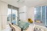 Floor-to-ceiling windows, polished tile flooring, and contemporary pendant lighting