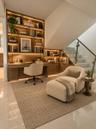 Custom built-in cabinetry featuring integrated LED shelf lighting and a coordinated workspace desk, complemented by a staircase with structural glass 