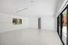 Open-concept interior with light-toned wood-finish flooring, recessed lighting, glass pendant fixtures, and floor-to-ceiling black-framed sliding glas