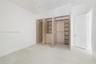 Custom built-in wood-finish cabinetry featuring integrated shelving, hanging rods, and a four-drawer storage unit