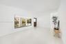 Minimalist interior featuring light-toned flooring, expansive picture window, recessed ceiling lighting, and solid wood door