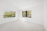 Bright room featuring wood-finish flooring, recessed lighting, and large windows with black frames