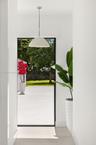 Minimalist pendant lighting, wide-format glass door, and exterior stone patio