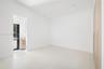 Minimalist room featuring wood-finish flooring, integrated floor-to-ceiling cabinetry, recessed lighting, and a glass-paneled exterior door