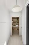 Built-in cabinetry featuring natural wood finish, four open shelves, minimalist dome pendant lighting, and wood-finish flooring