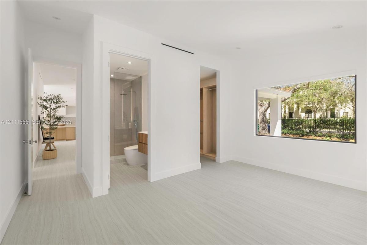 Interior room featuring wood-finish flooring, recessed lighting, expansive picture window, and built-in closet cabinetry