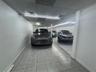 Enclosed parking area featuring tile flooring, smooth wall finishes, and LED linear lighting