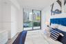 Floor-to-ceiling glass sliding door, wood-finish flooring, and recessed ceiling lighting, with access to a balcony featuring metal railing