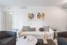 Neutral interior space featuring high ceilings, a flat-panel interior door with brushed metal hardware, and minimalist light-toned wall finishes