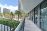 Covered balcony featuring wood-finish flooring, glass panel railings, and floor-to-ceiling sliding glass doors