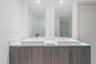 Dual-sink vanity featuring a solid surface countertop, rectangular vessel sinks, chrome fixtures, and full-height wall mirrors