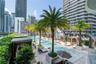 Elevated outdoor terrace featuring a multi-section swimming pool, stone tile decking, built-in wooden cabanas, and mature palm trees