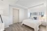 Tray ceiling with recessed lighting, light-tone wood-finish flooring, horizontal window, and interior door with a matte metallic lever handle