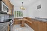 Kitchen featuring wood-finish cabinetry, stone-surface countertops, built-in breakfast nook with integrated bench seating, polished tile flooring, and